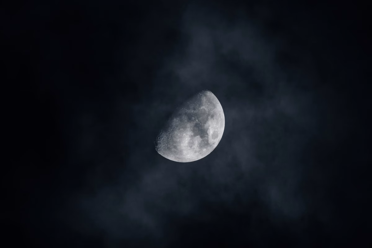 A crescent moon shines brightly in the night sky.